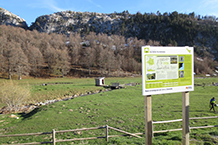 Explanada delante del refugio, con un panel explicativo y con el Paso del Salto del Caballo al fondo.