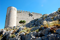 Torre circular suroeste y muralla del castillo del Montgrí. Se aprecian las almenas, las aspilleras y el matacán.