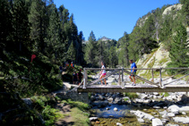 Cruzamos un puente de madera y giramos a la derecha barranco arriba.