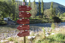 Señalización vertical con banderolas junto al río, eje vertebrador del valle.