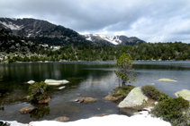 Lago de Malniu rodeado de árboles y de las montañas ceretanas.