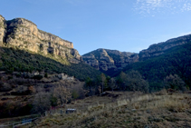 En medio de la Valldora, con las casas del Solà, Cal Teixidor y los riscos al fondo.