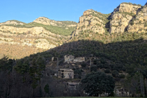 Las masías de Cal Guirre, Cal Teixidor y el Solà, con los acantilados de Busa al fondo.
