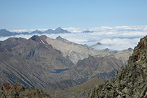 Hacia el O, pasamos de los esquistos metamórficos al mundo del granito. Observamos claramente el contraste entre los tonos marrones y el gris. En este caso, vemos el macizo de Certascan, junto con el Estany de Certascan, que es el lago natural más grande de toda la cordillera pirenaica.