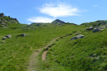 Giramos hacia la derecha (SE) y subimos por un prado. El pico Arlas al fondo.