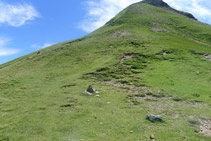 Hito de piedras y sendero que sube haciendo un par de zigzags.