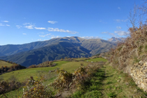 Bajamos por entre prados de pasto. Al fondo, el Tuc de la Cometa.